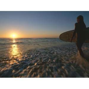 Woman Enters the Ocean with a Surfboard under Her Arm Photographic 