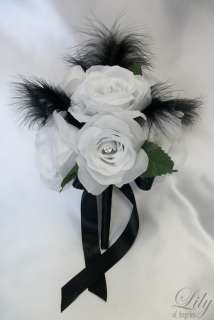   boutonnieres are made with one white rose bud with black ribbon bow