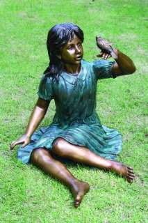  garden sculpture features beautiful young girl holding a small bird 